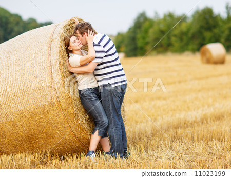 Young couple in love on yellow hay field on summer evening. 11023199