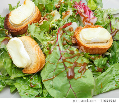 green salad with goat cheese and bread on plate green salad with goat cheese and bread on plate 11034548