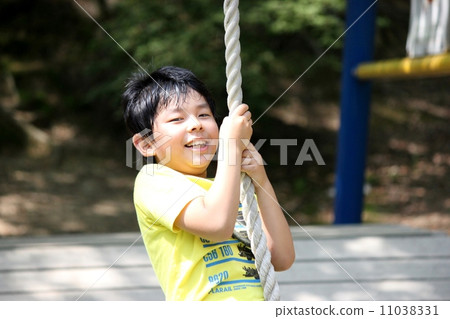 A boy holding on a rope 11038331