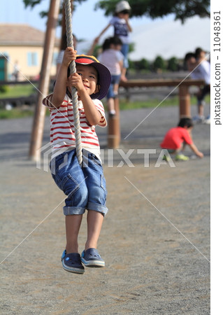Infant playing with Tarzan rope (4 years old child) 11048361
