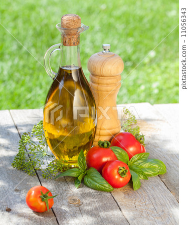 Olive oil bottle, pepper shaker, tomatoes and herbs Olive oil bottle, pepper shaker, tomatoes and herbs 11056343