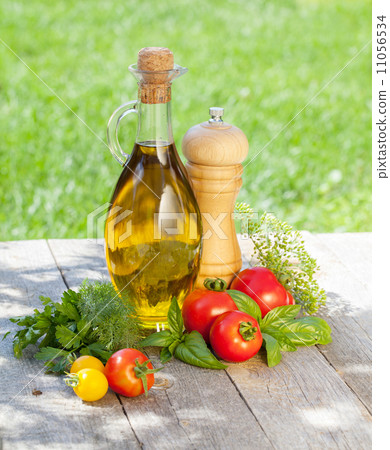 Fresh ripe tomatoes, olive oil bottle, pepper shaker and herbs Fresh ripe tomatoes, olive oil bottle, pepper shaker and herbs 11056534