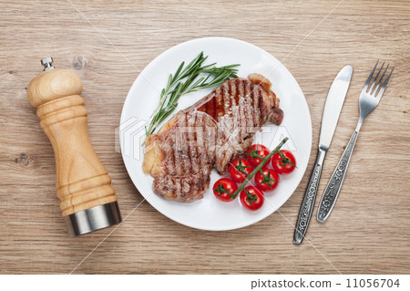 Sirloin steak with rosemary and cherry tomatoes on a plate Sirloin steak with rosemary and cherry tomatoes on a plate 11056704