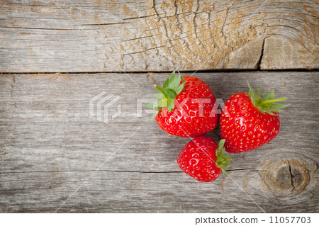 Ripe strawberries over wooden table background Ripe strawberries over wooden table background 11057703