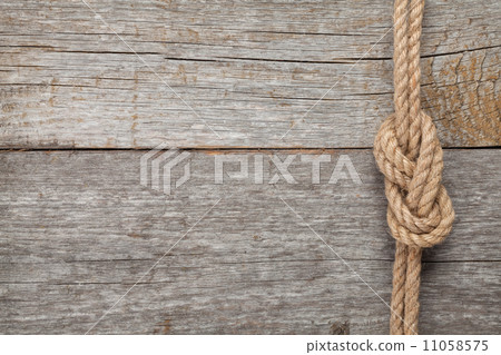 Ship rope knot on wooden texture background 11058575