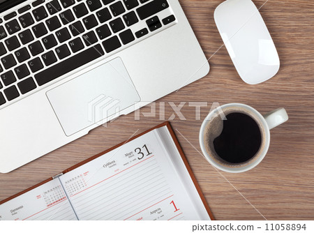 Notepad, laptop and coffee cup on wood table 11058894