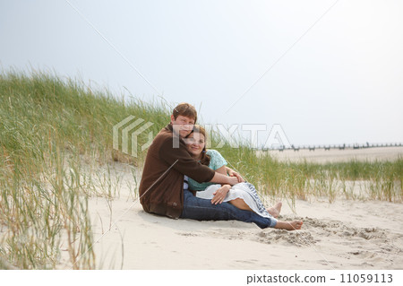 Young happy couple in love having fun on sand dunes of the beach 11059113