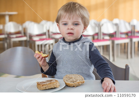 Little boy with eating bread and apple in kindergarten Little boy with eating bread and apple in kindergarten 11059170