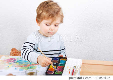 Cute little boy of two years having fun painting 11059196