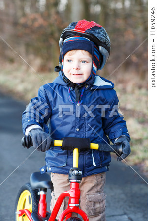 2 years old toddler riding on his first bike 11059246
