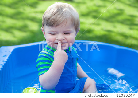 Little blond toddler boy playing with water in summer 11059247