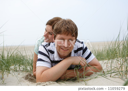Young happy couple in love having fun on sand dunes of the beach 11059279