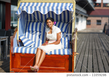 Beautiful happy indian bride sitting in beach chair Beautiful happy indian bride sitting in beach chair 11059286