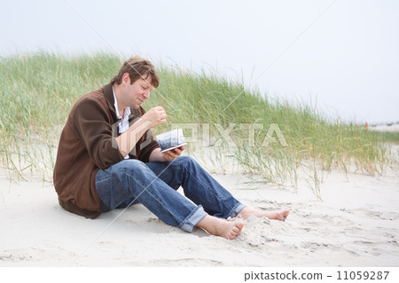 Young happy man relaxing on sand dunes of the beach of St.Peter Young happy man relaxing on sand dunes of the beach of St.Peter 11059287