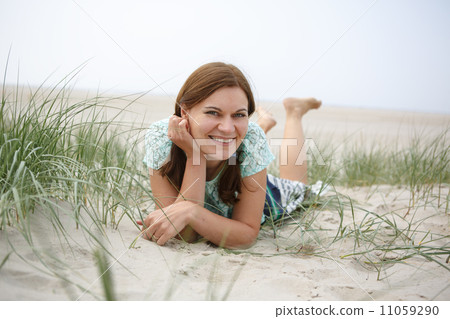 Young happy girl relaxing on sand dunes of the beach of St.Peter 11059290