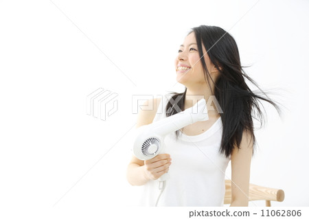 A young lady who dries her hair with a hair dryer 11062806