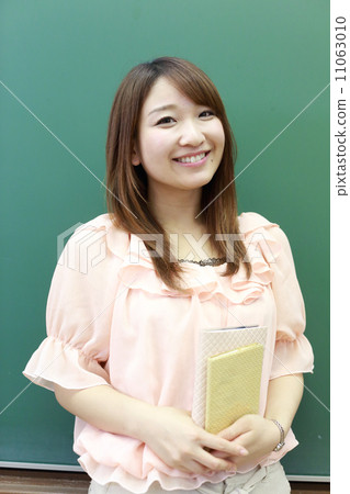 A young woman standing in front of the blackboard A young woman standing in front of the blackboard 11063010