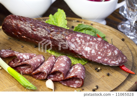 sausages on a wooden plate with vegetables in a restaurant 11065028