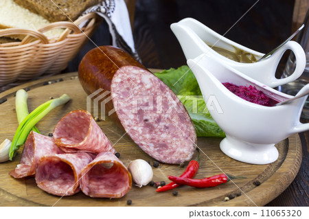 sausages on a wooden plate with vegetables in a restaurant 11065320