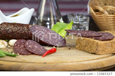 sausages on a wooden plate with vegetables in a restaurant 11065327