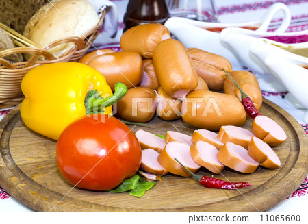 sausages on a wooden plate with vegetables in a restaurant sausages on a wooden plate with vegetables in a restaurant 11065600