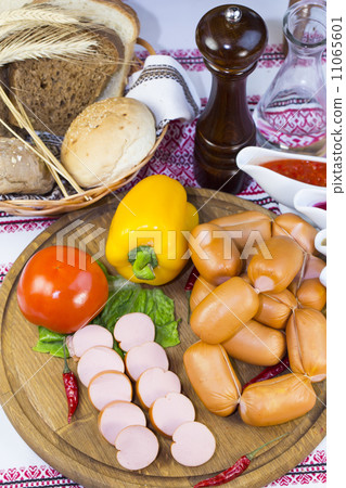 sausages on a wooden plate with vegetables in a restaurant 11065601