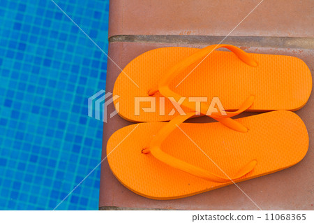 orange flip flops on pool edge orange flip flops on pool edge 11068365