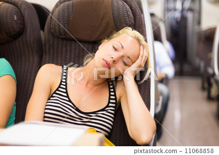 Lady traveling napping on a train. 11068858