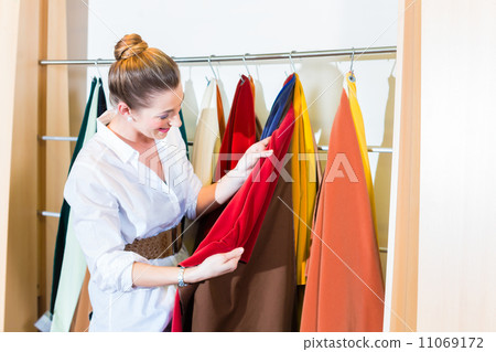 Woman picking seat cover in furniture store 11069172