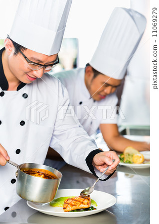 Asian Chefs in restaurant kitchen cooking 11069279