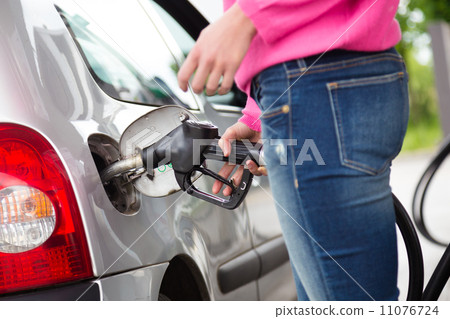 Lady pumping gasoline fuel in car at gas station. 11076724