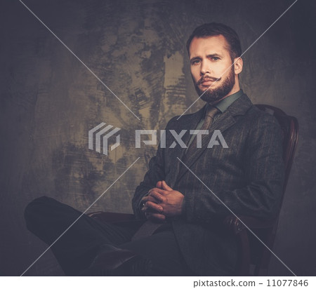 Handsome well-dressed with stick sitting in leather chair 11077846