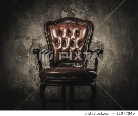 Comfortable wooden chair against concrete wall 11077849