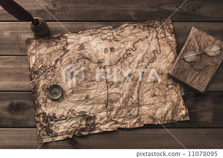 Compass, book and inkwell on a vintage map 11078095