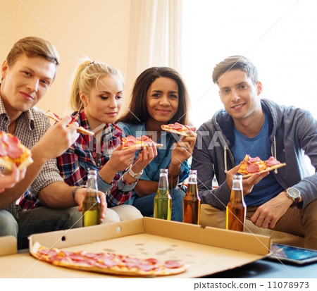 Group of young multi ethnic friends with pizza and bottles of drink celebrating in home interior Group of young multi ethnic friends with pizza and bottles of drink celebrating in home interior 11078973