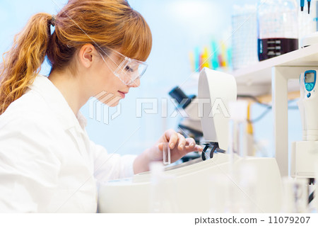 Attractive young scientist pipetting. Attractive young scientist pipetting. 11079207