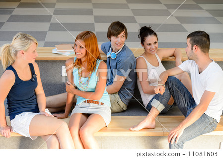 Students talking sitting on school bench 11081603
