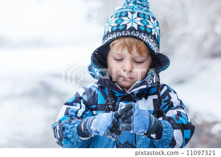 Adorable toddler boy having fun with snow on winter day Adorable toddler boy having fun with snow on winter day 11097321