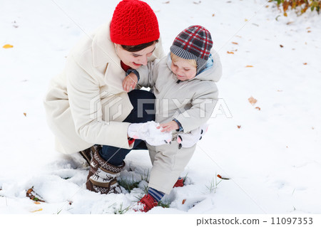 Mother and toddler boy having fun with snow on winter day Mother and toddler boy having fun with snow on winter day 11097353