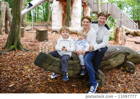 Family of four sitting on a bench in autumn park Family of four sitting on a bench in autumn park 11097777