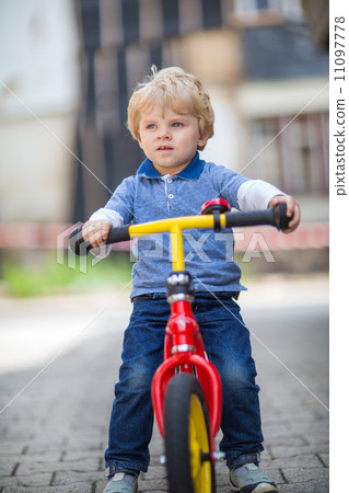 2 years old toddler riding on his first bike 2 years old toddler riding on his first bike 11097778