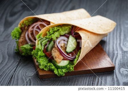 pair of fresh juicy wrap sandwiches with chicken and vegetables 11100415