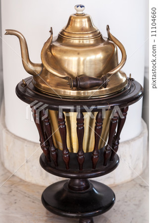 Shining Arabic teapot on dark wooden base 11104660