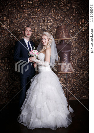 happy groom and the charming bride with a bouquet from roses in studio on a brown background 11106048