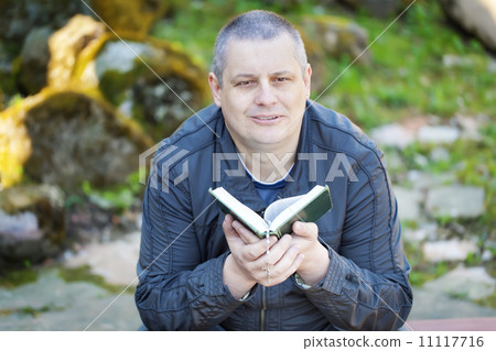 Religious man with Holy Bible at Place of Worship 11117716