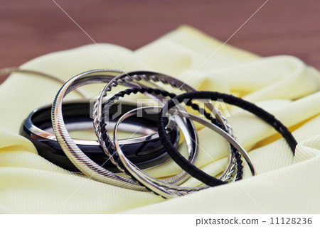 Various bracelets on a yellow fabric Various bracelets on a yellow fabric 11128236