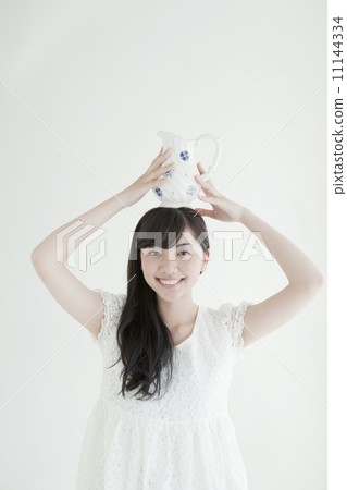 拿著在她的頭的一位小姐一個水罐 拿著在她的頭的一位小姐一個水罐 11144334