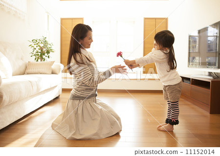 A girl giving a carnation to a mother 11152014