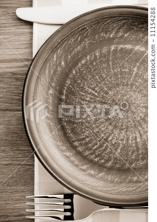 plate, knife and fork at napkin on wood 11154288