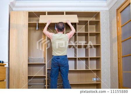 The man is engaged in repair and furniture assemblage.. The man is engaged in repair and furniture assemblage.. 11155880